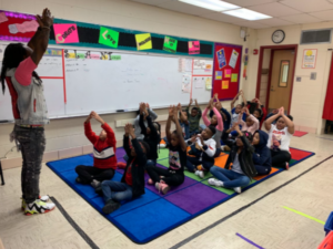 Teacher leading students in a breathing exercise